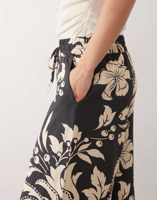 Bogatt Petite wide leg pant in black with cream floral prin